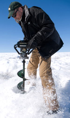 Joughin drilling a hole for installing a seismometer near a supra glacial lake in Greenland. Credit; Chris Linder